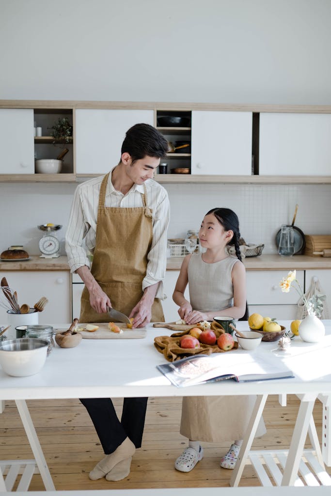 A father and daughter enjoy baking together in a modern kitchen.