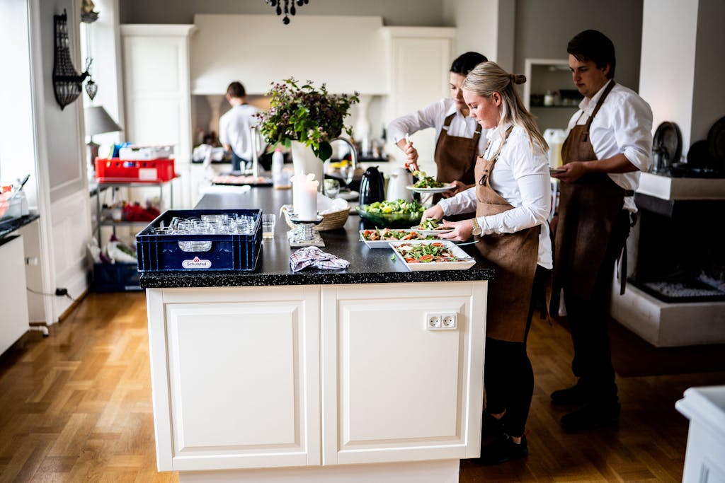 Chefs in a modern kitchen preparing dishes with precision and teamwork, highlighting culinary expertise and professionalism.