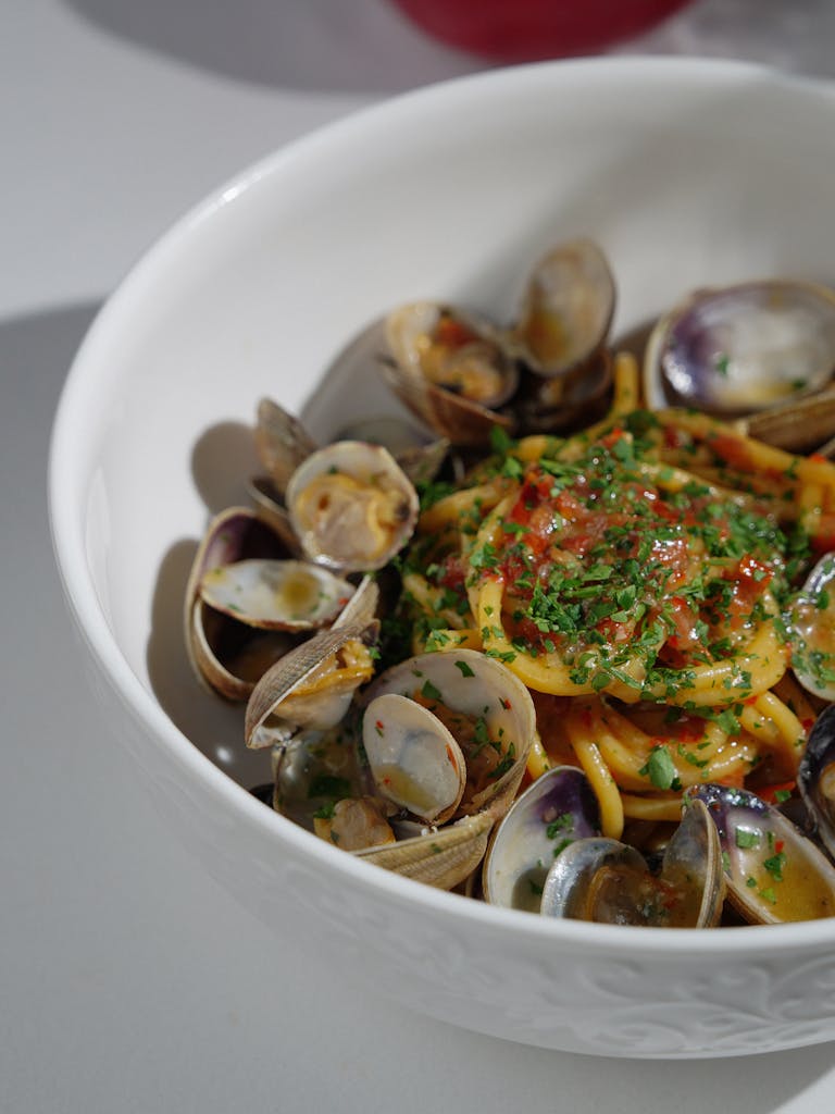 Close-up of clam linguine garnished with herbs, perfect for seafood lovers.